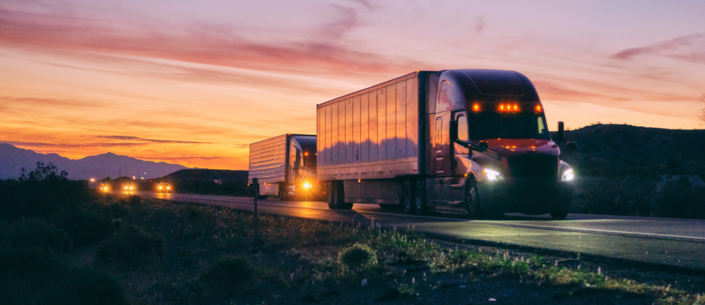 Two Countryside Services semi tractors with large trailers at sunset