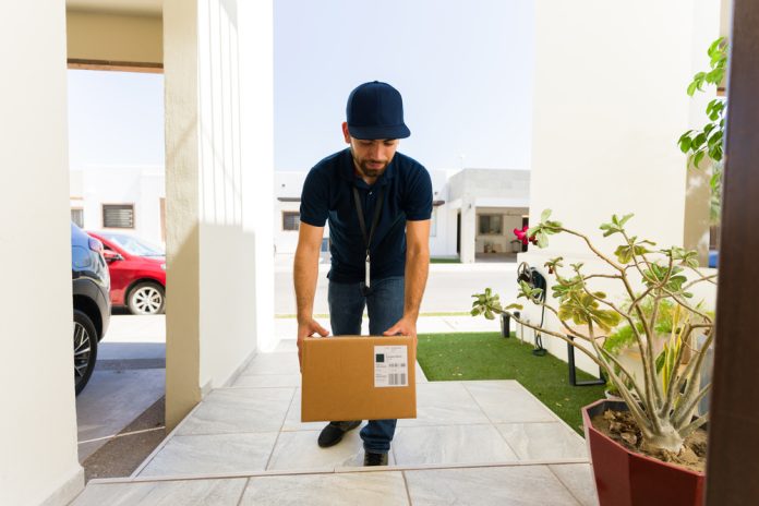 Delivery driver carefully carrying a package to a customer's front door